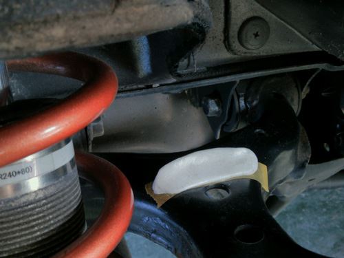 Putty pyramid attached to the masking tape on the upper control arm